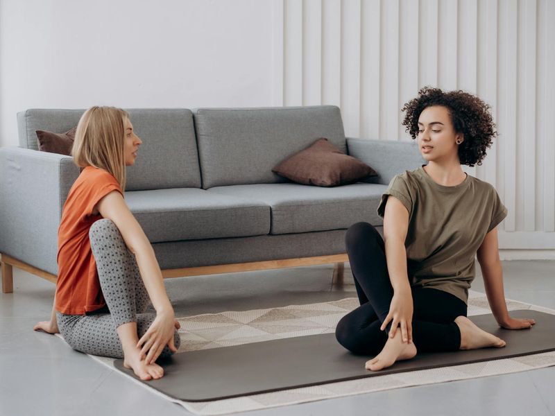 Person practicing a focused yoga pose in a minimalist room.
